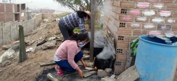 Outside cooking some of the food using wood fuel